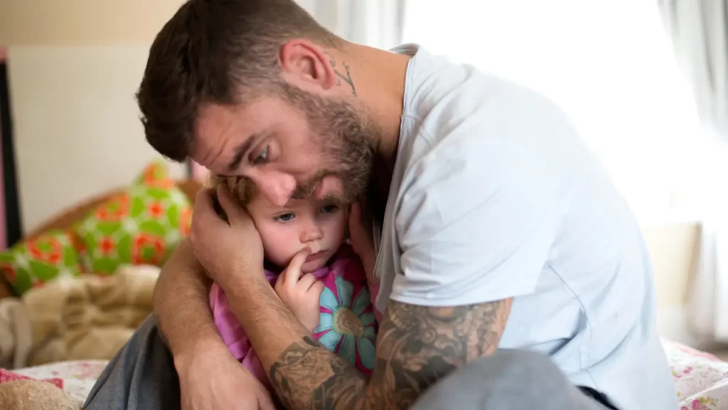 Pai abraçando filho para acalmar, mostrando apoio emocional.